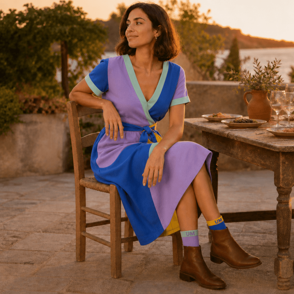 Priya at outdoor dinner wearing mismatched primary-block and lavender-fields UNMATCHED socks